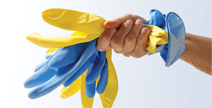 photo of a cleaner holding a stack of plastex gloves